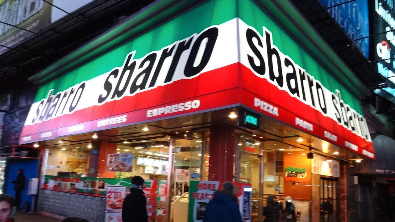 Sbarro restaurant exterior with green, white, and red awning, displaying the brand name and food items