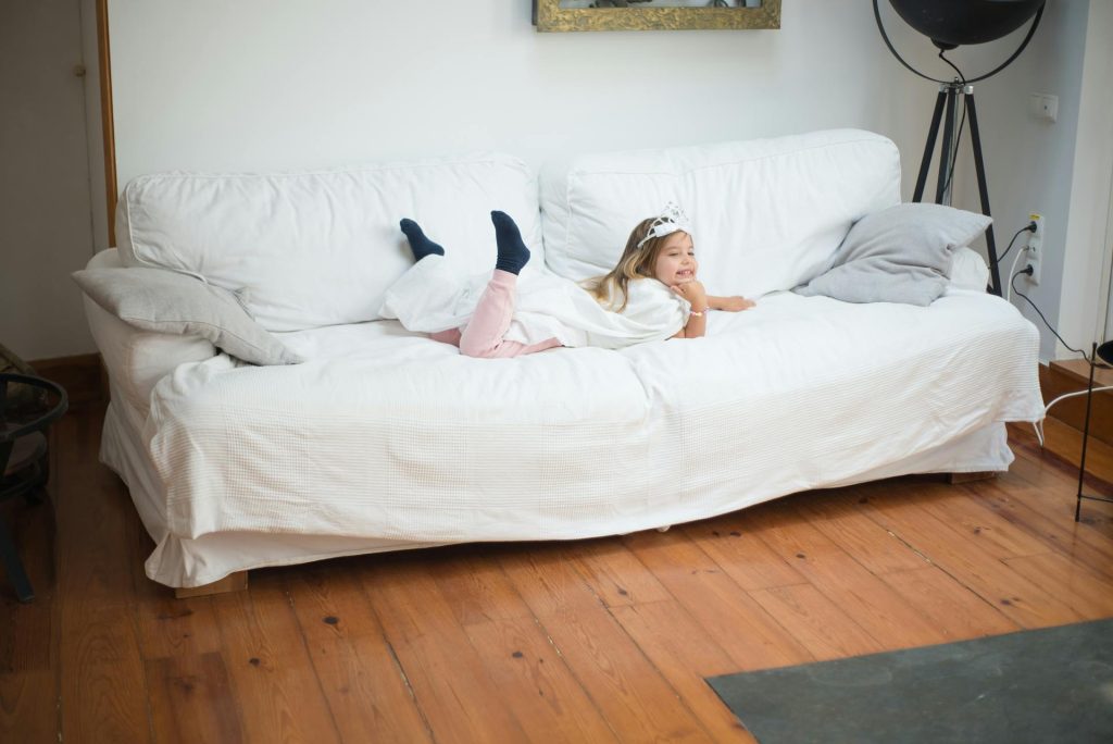 A Girl with Tiara Lying on Front on a Sofa