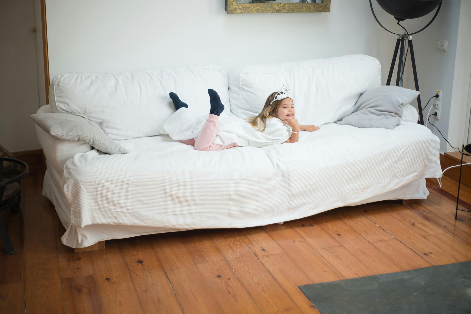 A Girl with Tiara Lying on Front on a Sofa