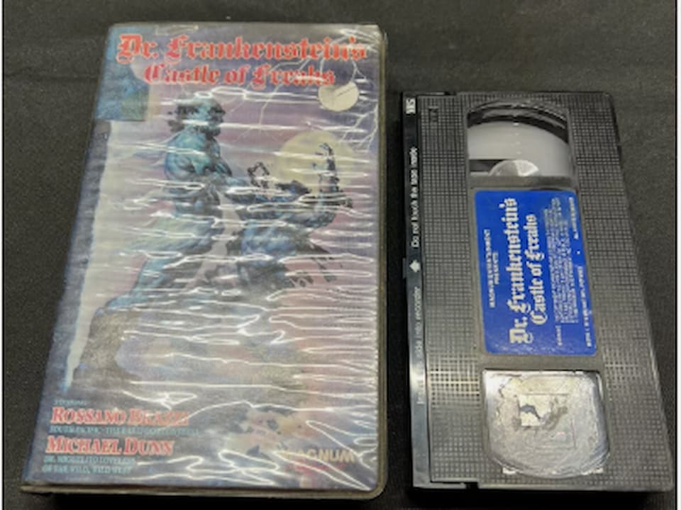 Frankenstein's Castle of Freaks 1981 VHS, vintage horror artwork with monster figures, castle background, dark color scheme, classic typography, VHS clamshell or slipcase visible