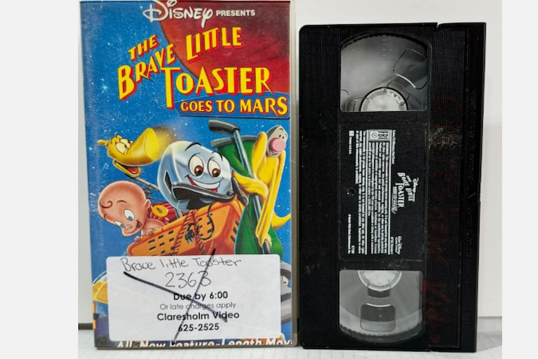  VHS tape and case for The Brave Little Toaster Goes to Mars (1998), animated cover featuring the toaster and appliance friends in a space setting, bold title text, colorful backdrop of stars and planets