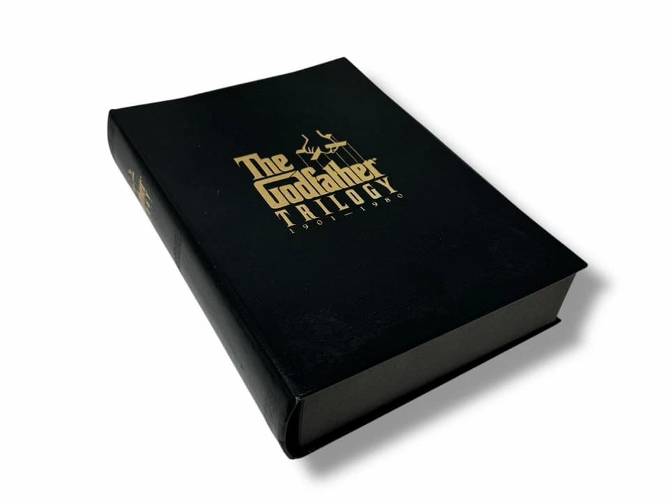 The Godfather Trilogy VHS box set (1992), black slipcase with gold lettering, includes all three films, spine art forms iconic puppet hand logo, tapes neatly arranged