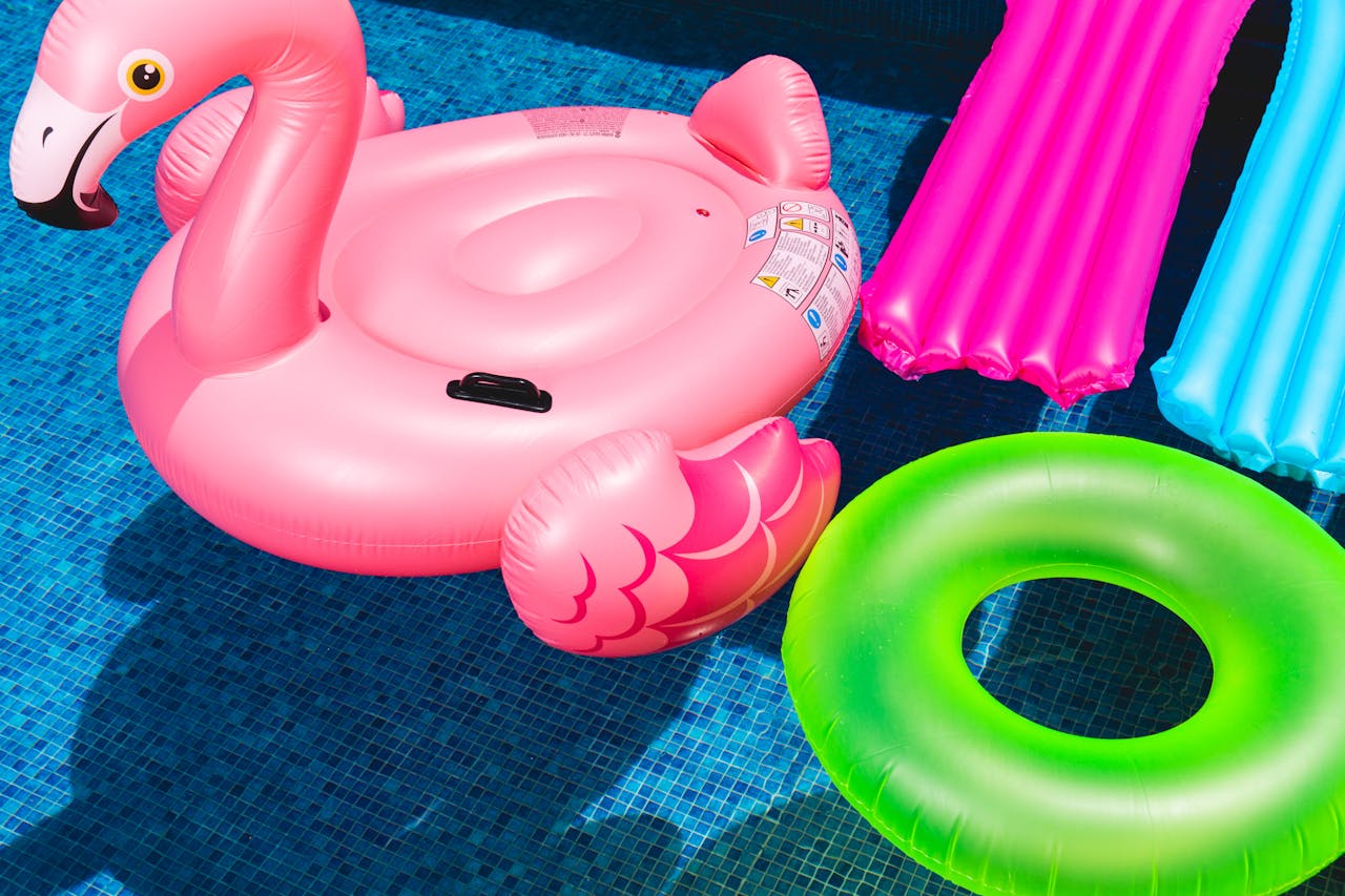 Pink Flamingo Inflatable Ring and Green Inflatable Ring on Swimming Pool
