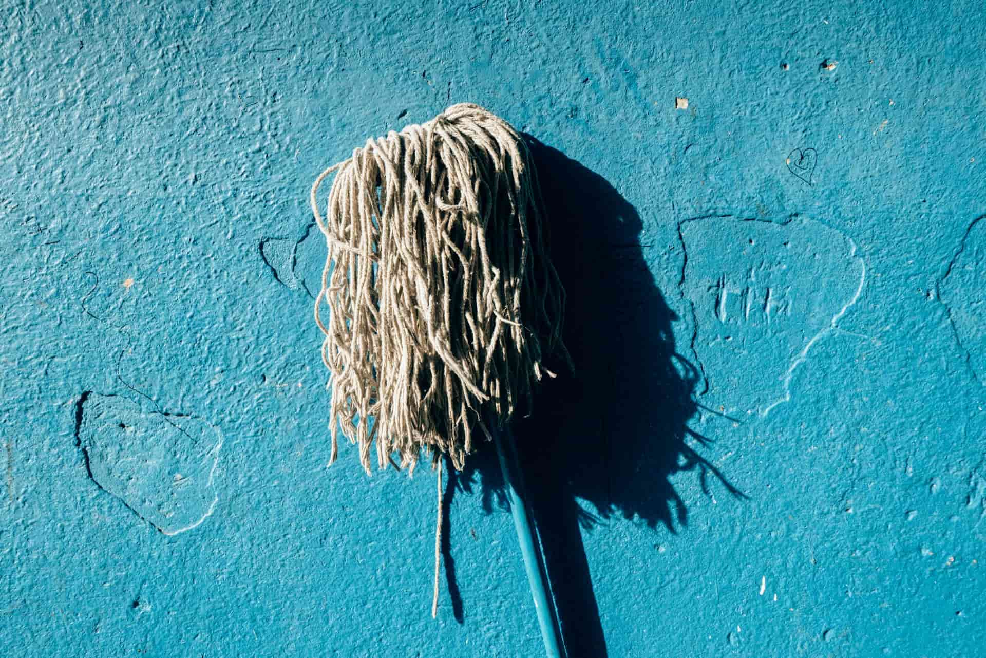 Mop / broom in front of blue background