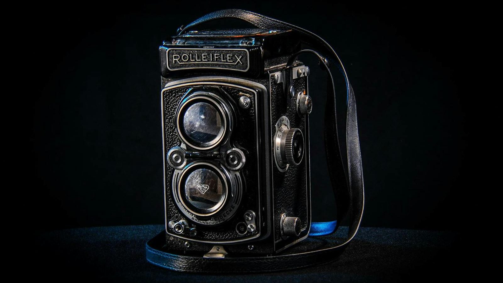 Classic Rolleiflex twin-lens reflex camera with a dark backdrop, highlighting its vintage design.