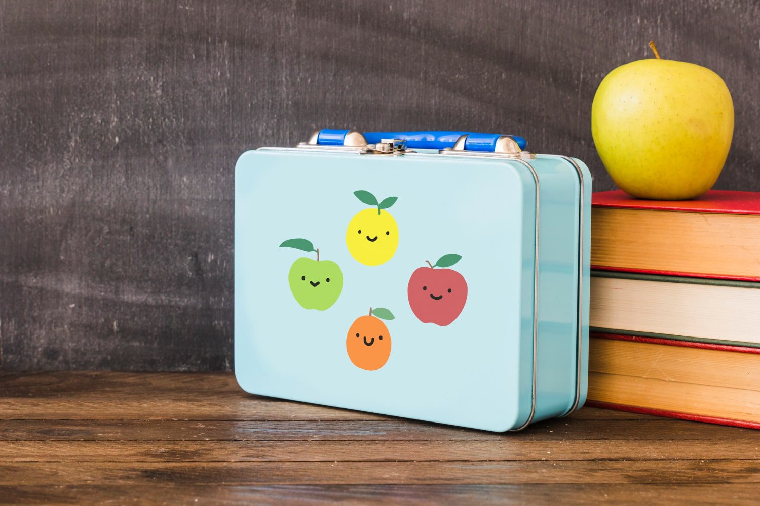 vintage Lunchbox near stack of books and apple