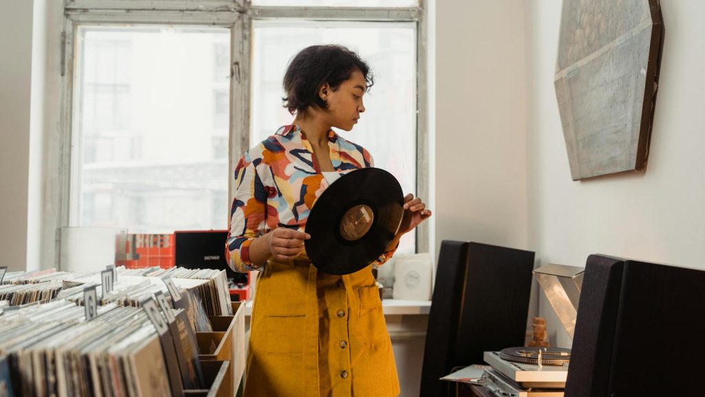 Stylish woman browsing vinyl records in a cozy shop. Music enthusiasts will love the vintage vibe.