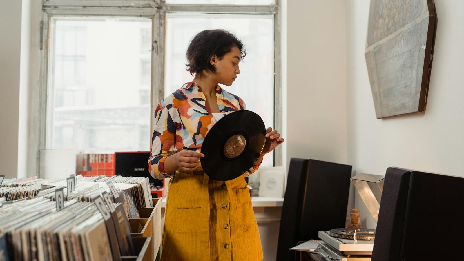 Stylish woman browsing vinyl records in a cozy shop. Music enthusiasts will love the vintage vibe.