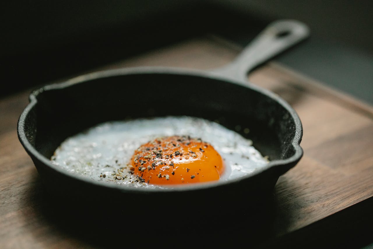 Delicious breakfast with fried eggs on wooden board