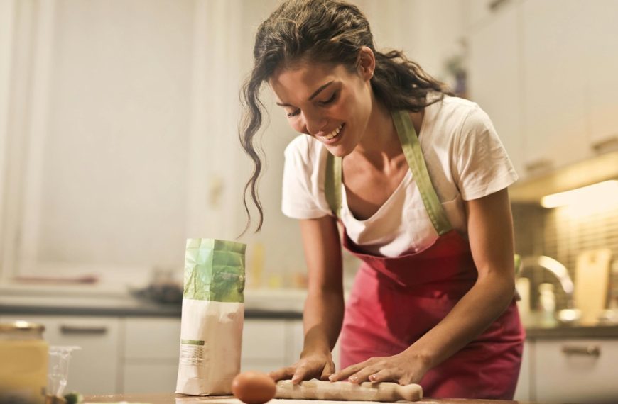 Woman cooking in kitchen wearing an apron