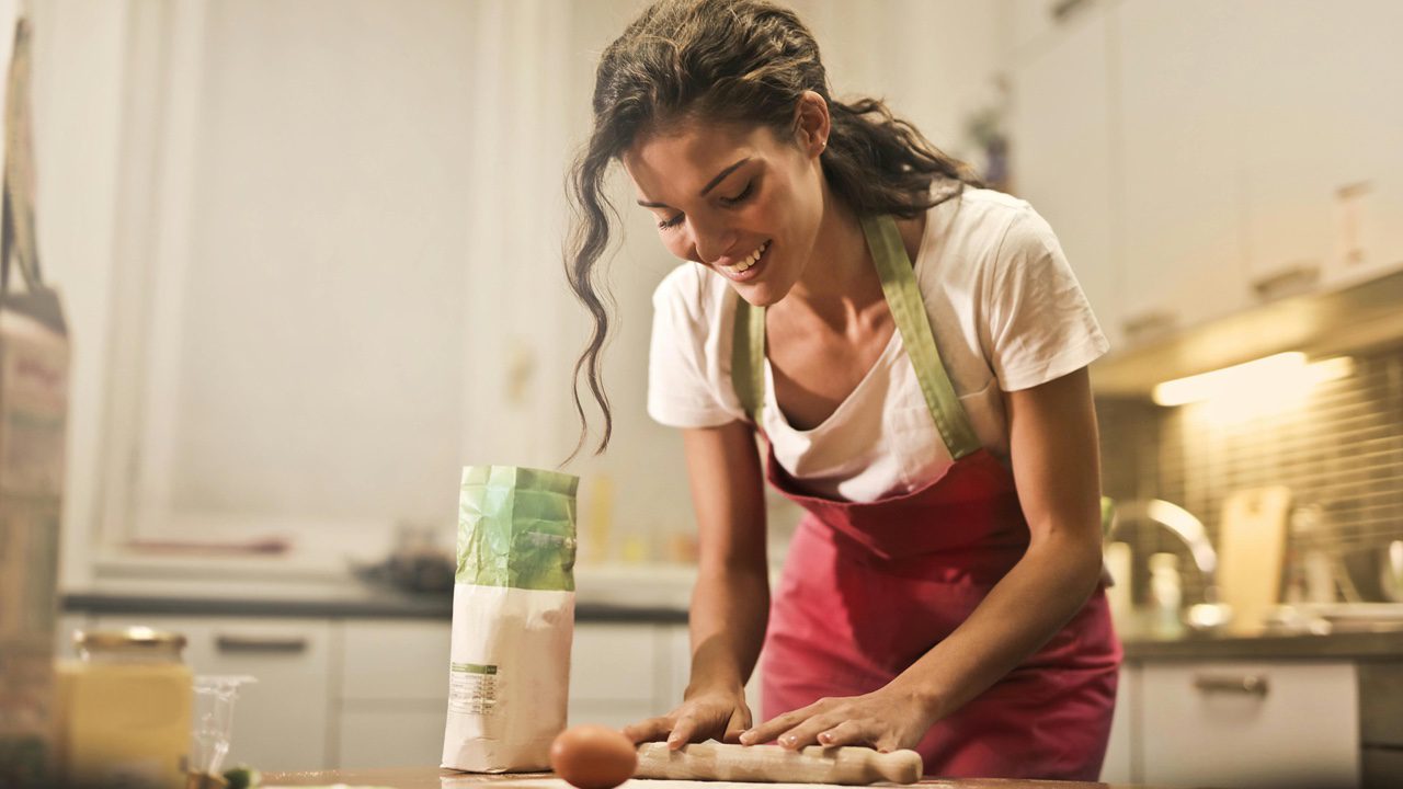 Woman cooking in kitchen wearing an apron