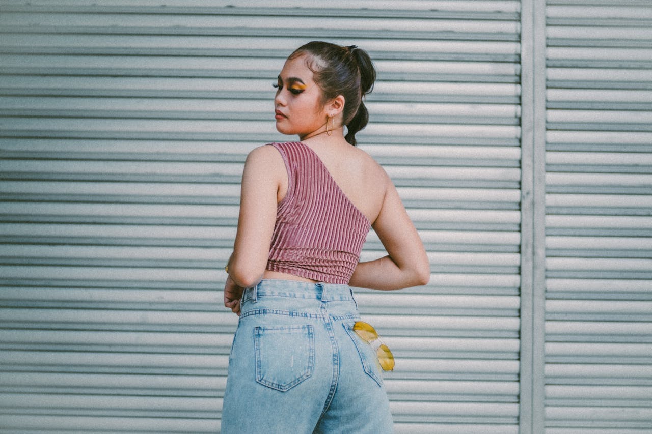 A Woman in Pink One Shoulder Top Standing Near the Roll Up Door