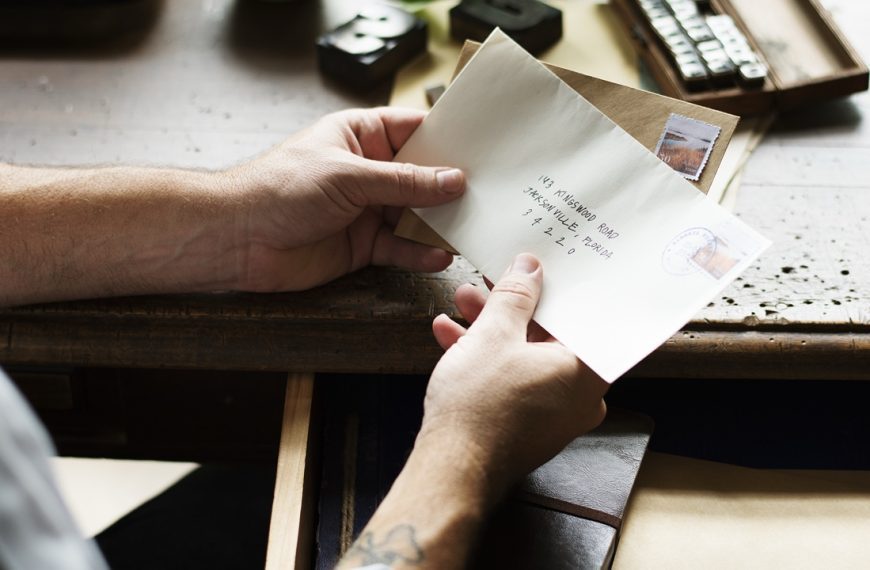 Man holding letters from desk drawer