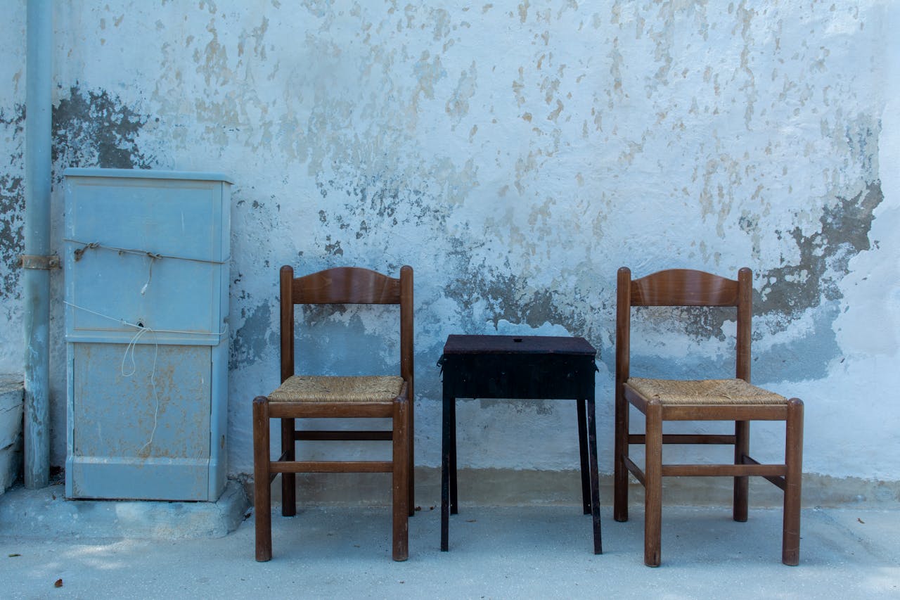 Table and Chairs near Cracked Wall