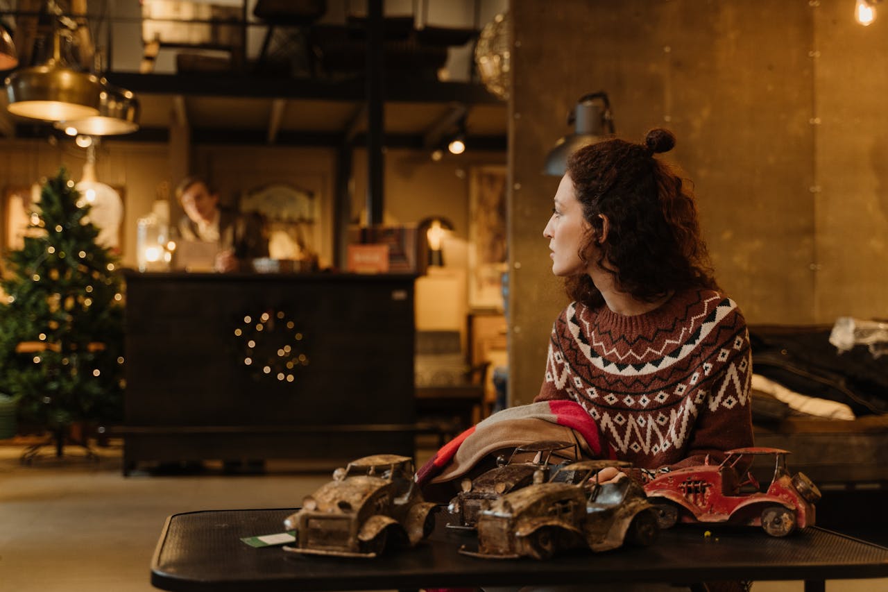 Brunette Woman in Sweater Sitting by Table at Christmas