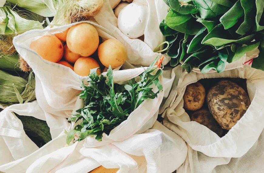 fresh vegetables in eco cotton bags on table in the kitchen.