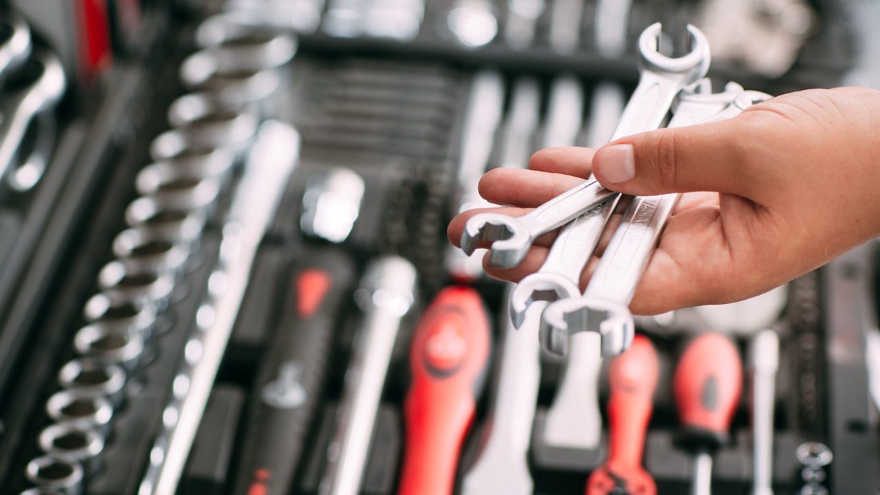 Customers or worker (builder, repairman, handyman) at the store chooses wrench instrument (tools). Display of tools shop marketing for home and auto repair