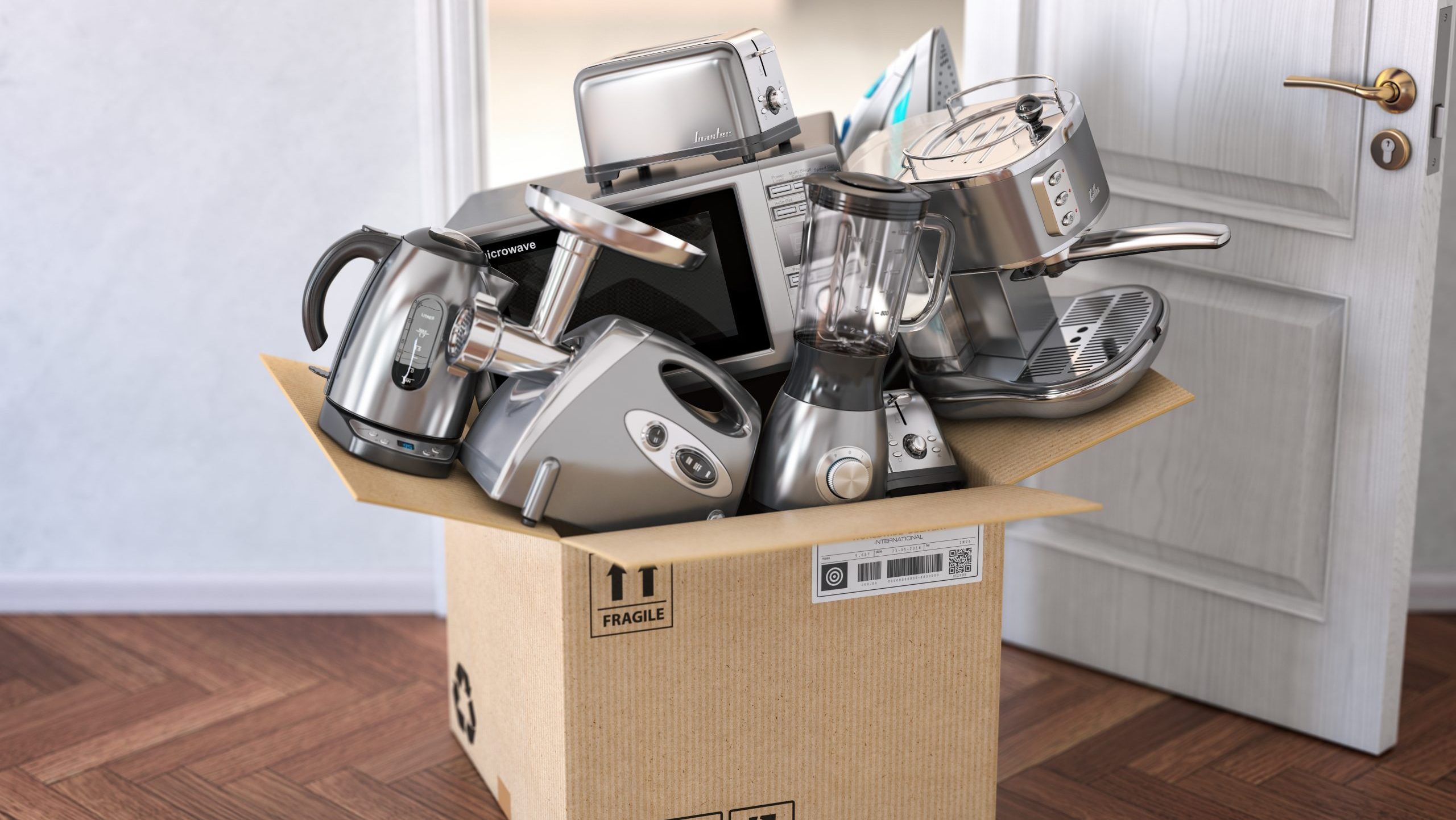 Household kitchen appliances in open cardboard box in front of