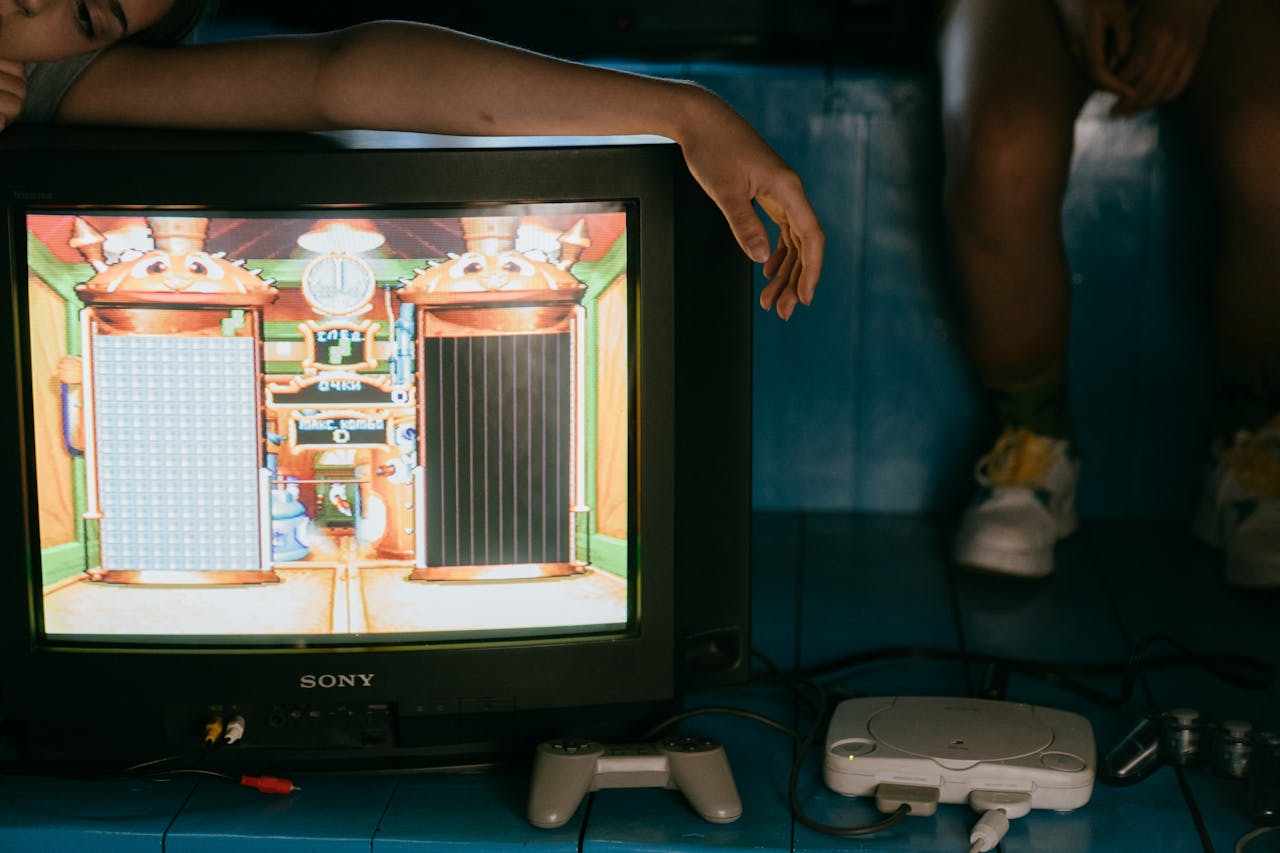 Crop woman leaning on TV monitor near ethnic friend