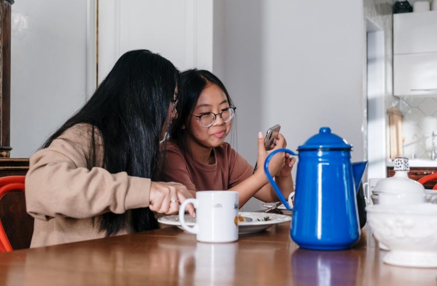 Woman in Brown Sweater Sitting Beside Brown Wooden Table