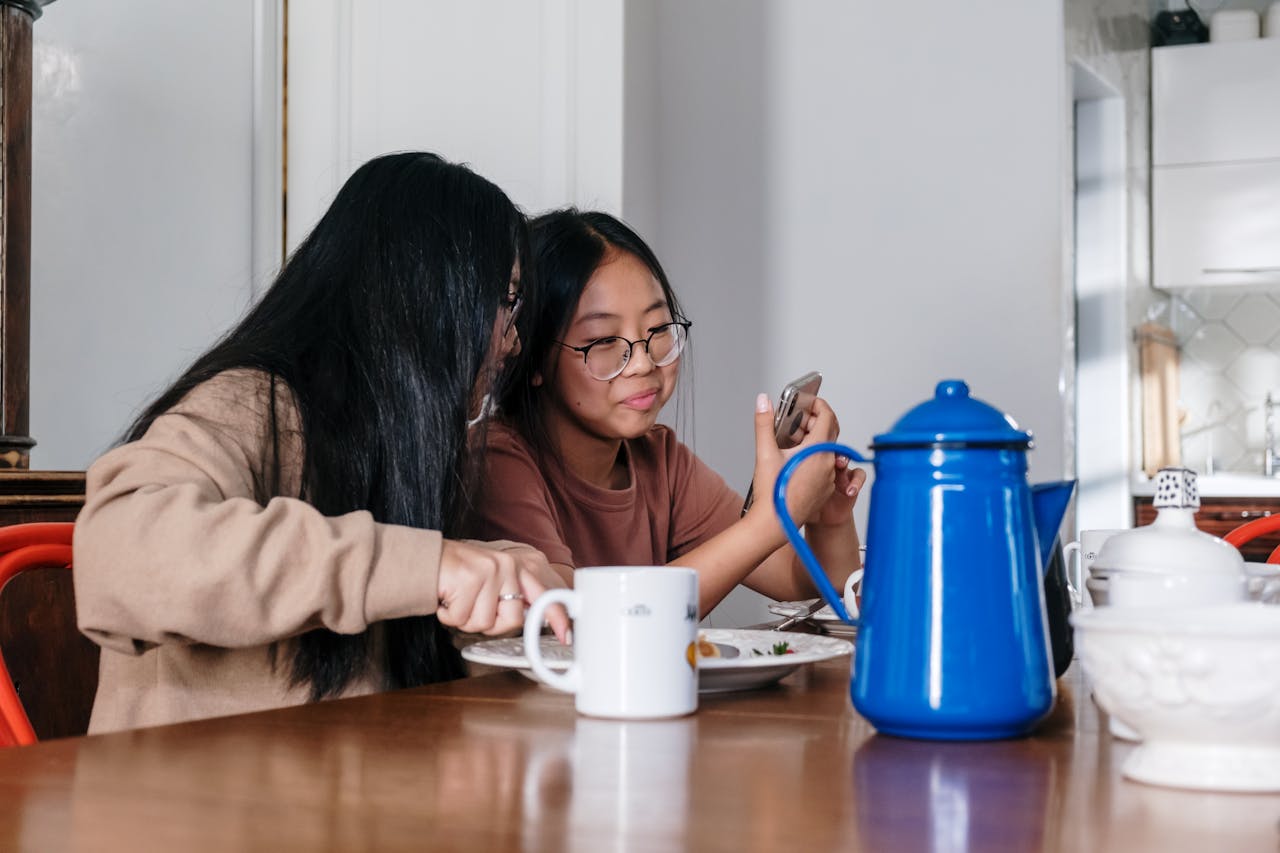 Woman in Brown Sweater Sitting Beside Brown Wooden Table