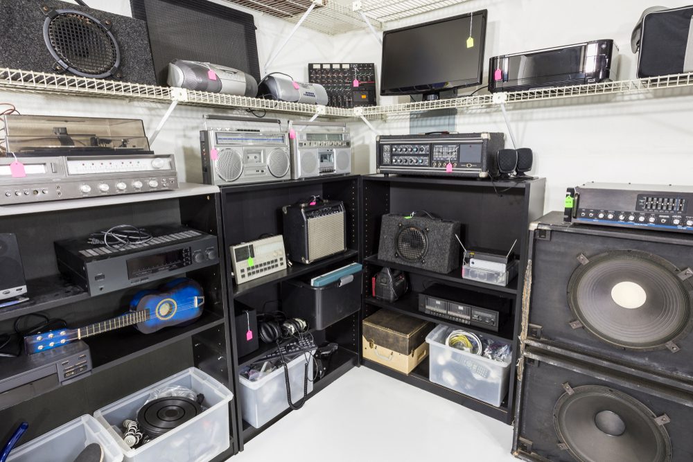Vintage music and electronics store set with shelves full of equipment.