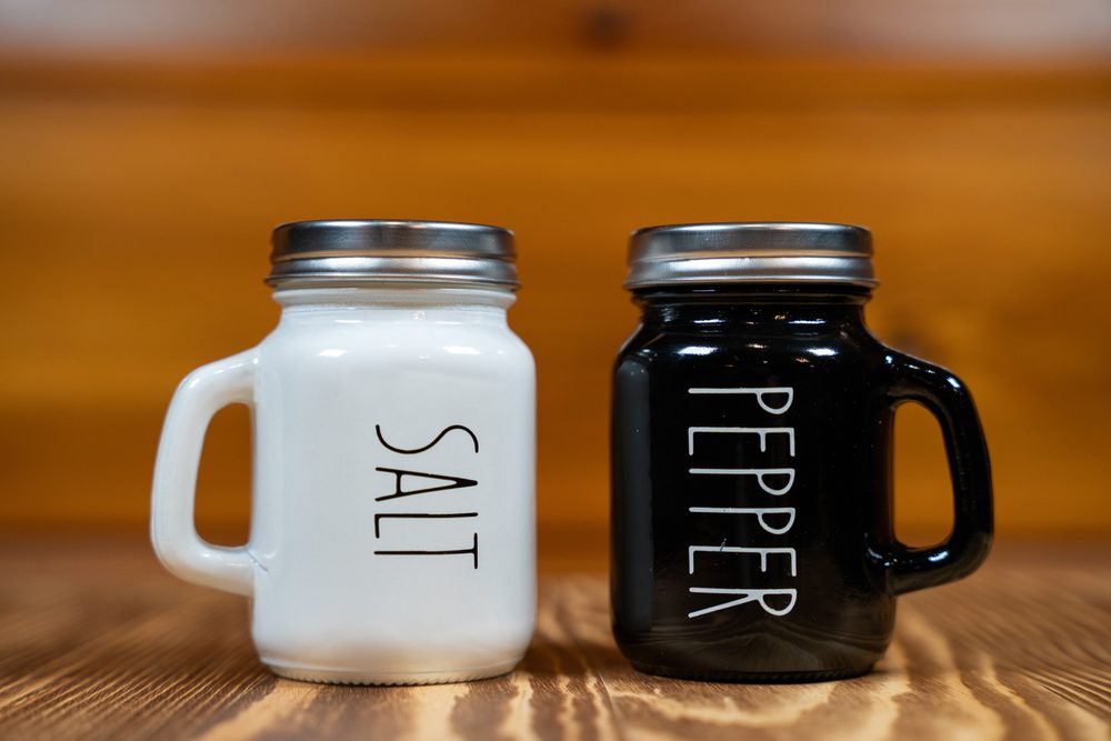 Salt and pepper shakers on wooden background.