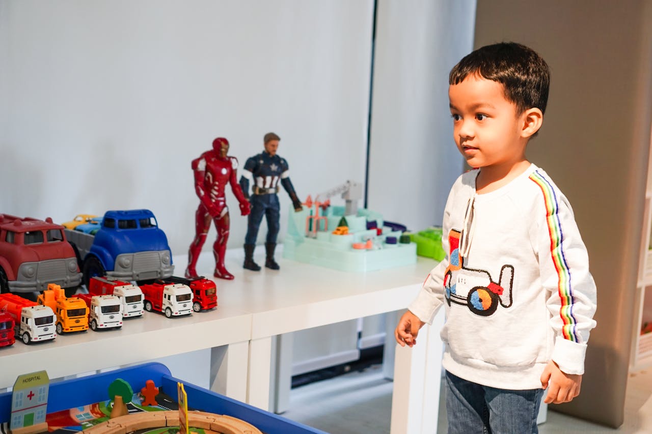 Boy Standing by Table with Toys