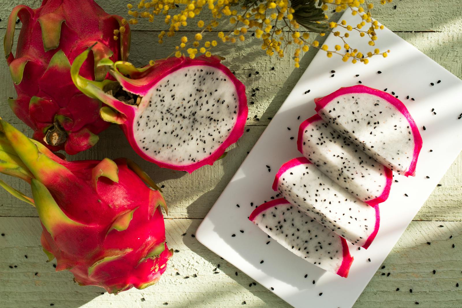 Vibrant dragon fruit slices on wood showcase tropical freshness and healthy eating.