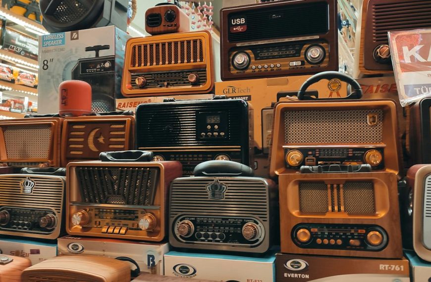 A variety of retro and vintage radios stacked in an indoor store, showcasing nostalgia.