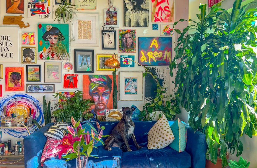 a living room with a blue couch and lots of pictures on the wall