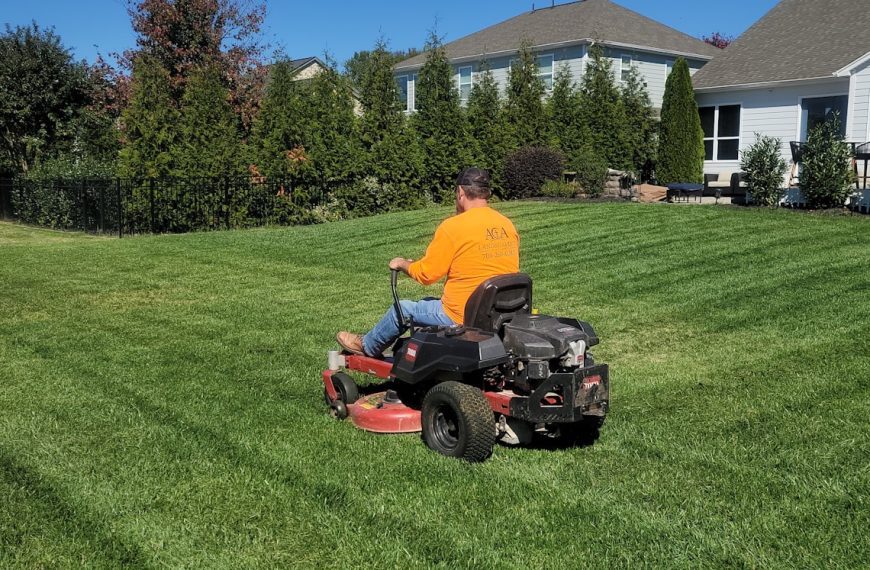 A man riding on the back of a lawn mower