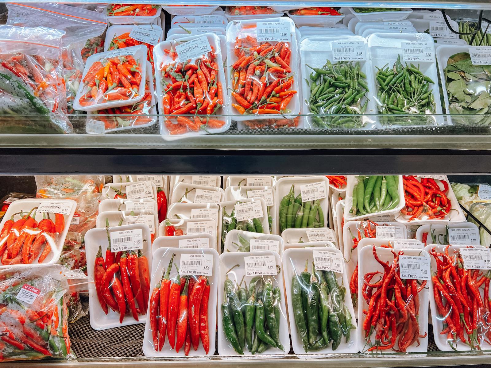 A vibrant variety of fresh chili peppers displayed in a market in Surabaya, Indonesia.