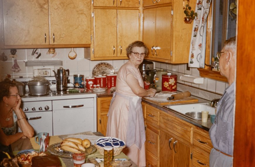 a woman standing in a kitchen next to a man