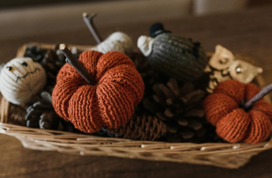 A charming basket of knitted Halloween decorations, perfect for a cozy autumn atmosphere.