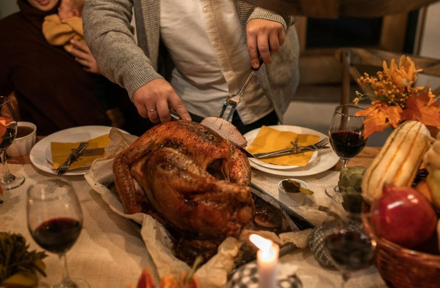 A festive Thanksgiving family gathering with carving a roasted turkey and holiday decor.