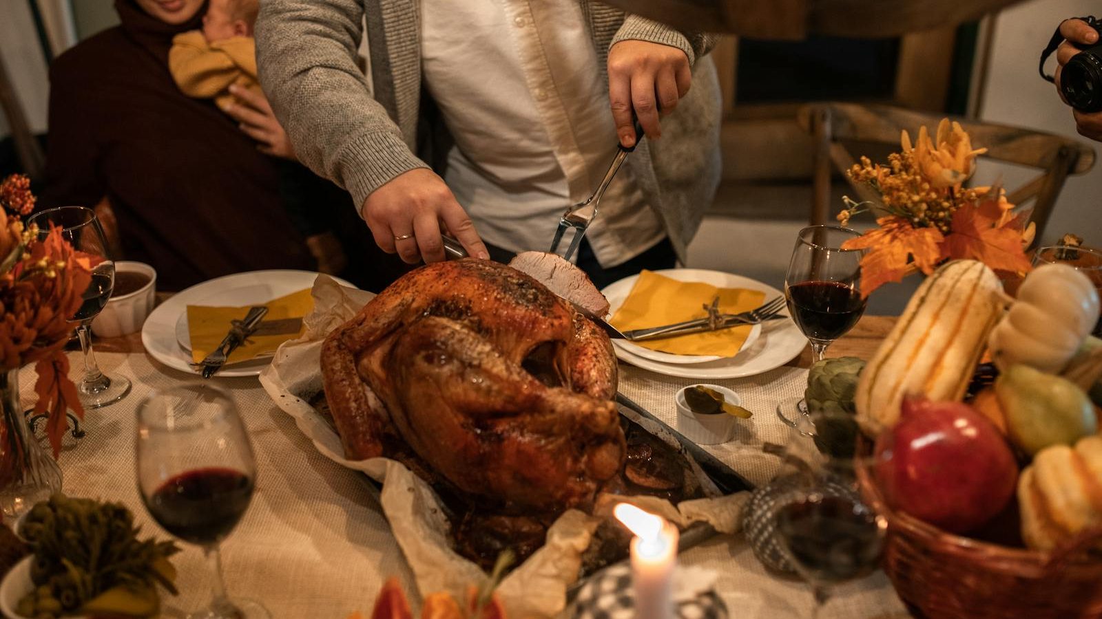 A festive Thanksgiving family gathering with carving a roasted turkey and holiday decor.