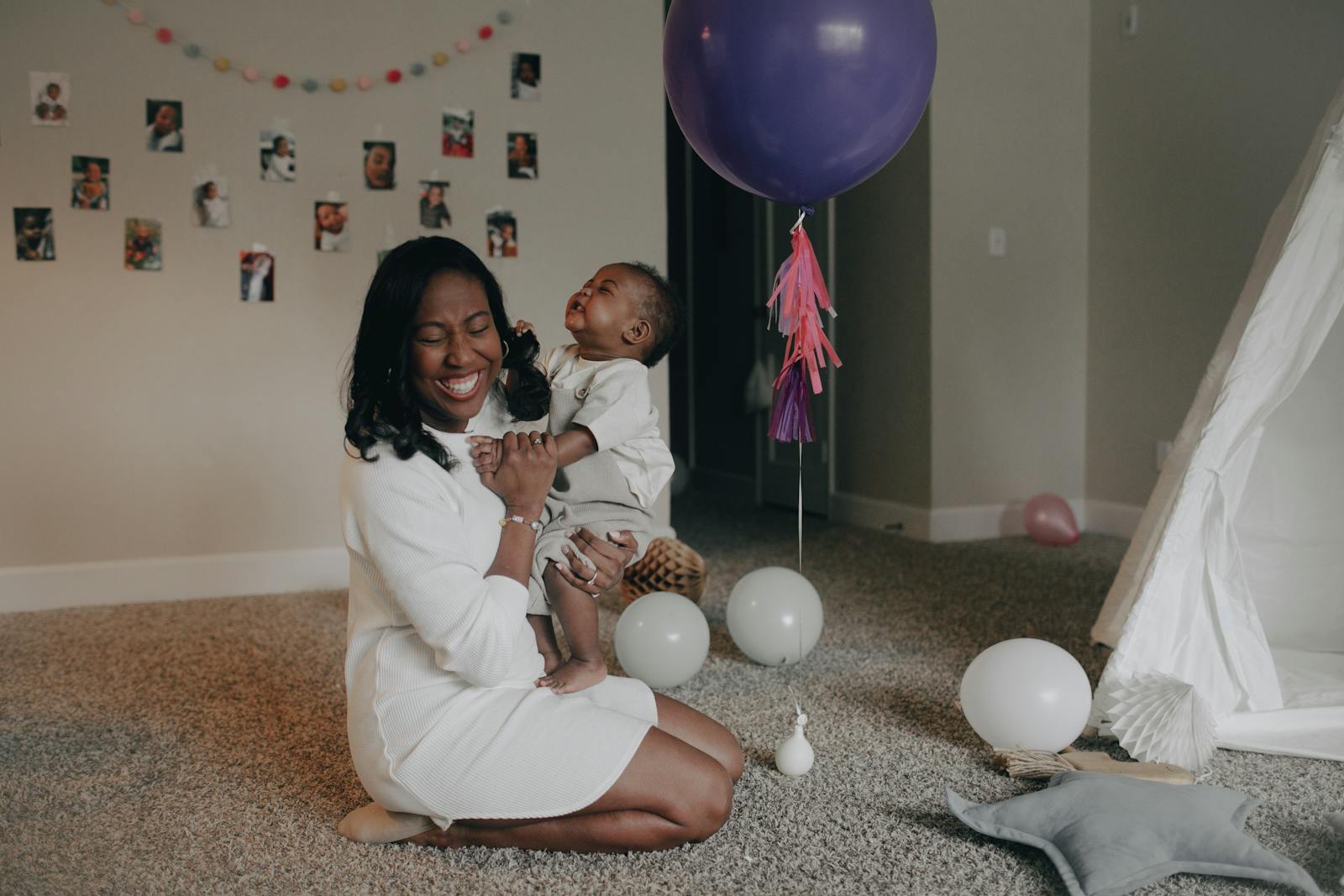 A happy mother and child enjoying playful moments at home with balloons.