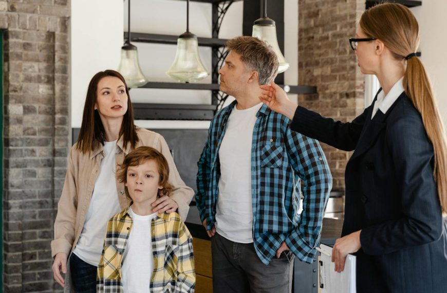 A family visits a modern home guided by a real estate agent during an open house tour.
