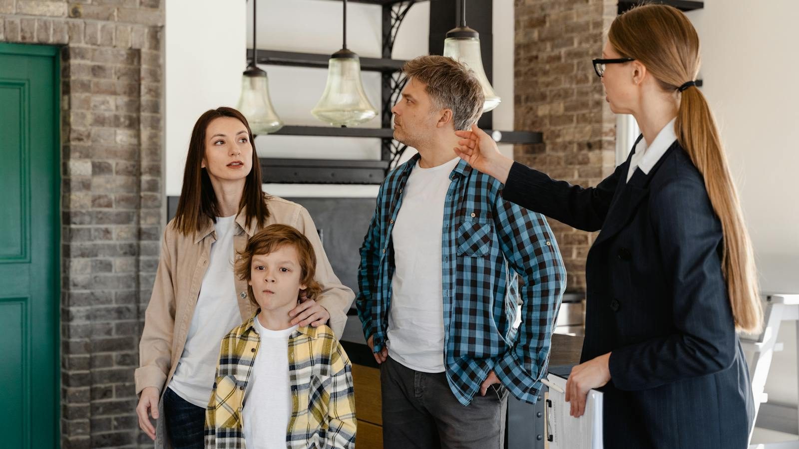 A family visits a modern home guided by a real estate agent during an open house tour.