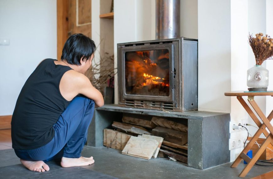 A person enjoys the warmth of a fireplace in a cozy Portuguese living room setting.