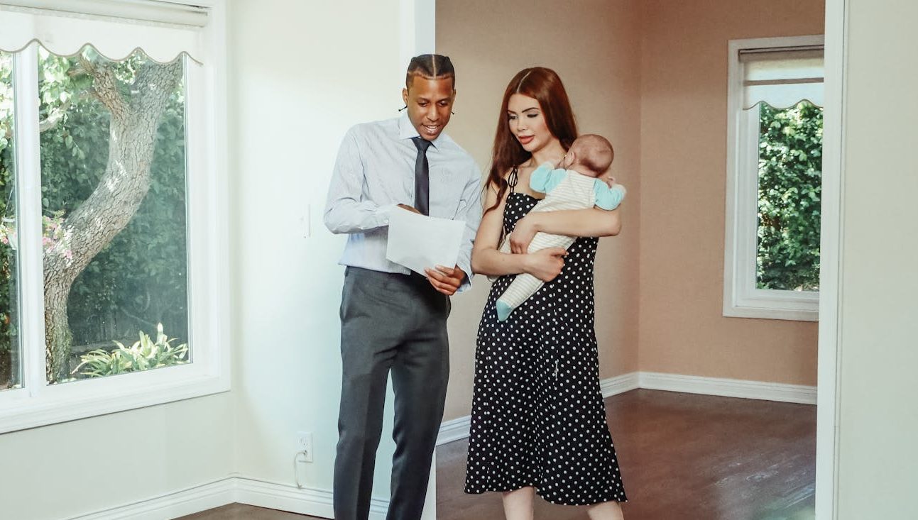 A family explores their potential new home with a realtor during a house tour.