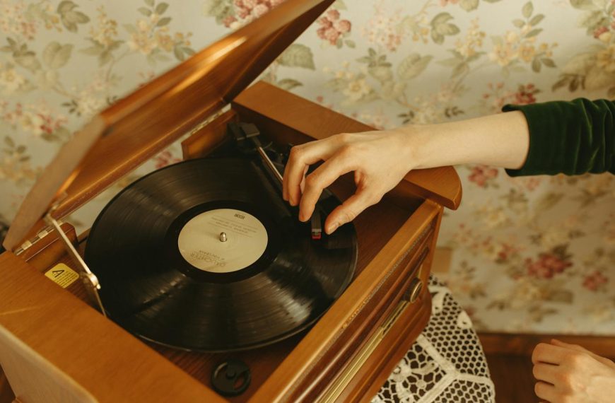 Hand playing a vinyl record on a vintage turntable in a retro styled room.