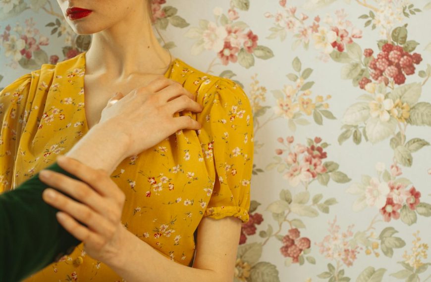 Close-up portrait of a woman in a yellow floral dress with an expressive pose.