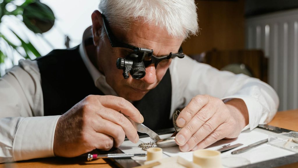 A watchmaker meticulously repairing a pocket watch with precision tools and a magnifier.