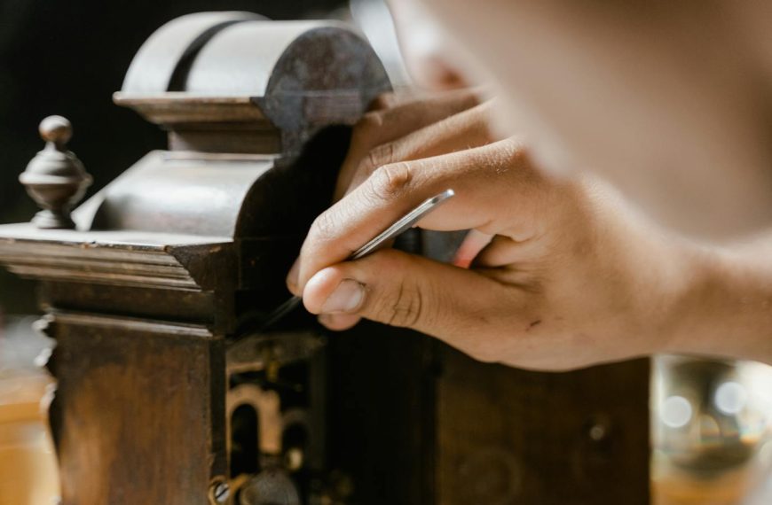 Close-up of hands skillfully restoring an antique wooden clock, highlighting craftsmanship.