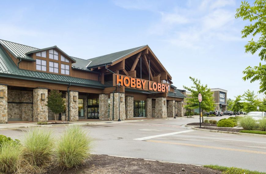 Front view of a Hobby Lobby store with clear blue sky and parking area.
