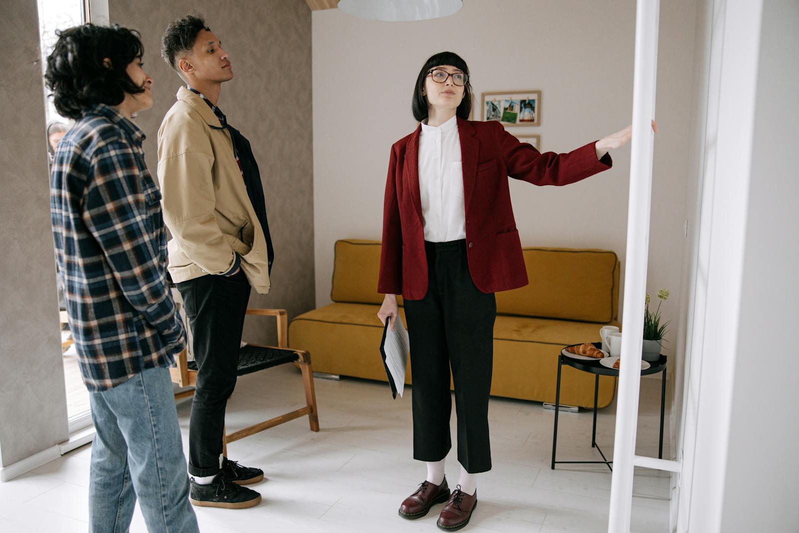 Realtor guiding potential buyers through a stylish apartment viewing.