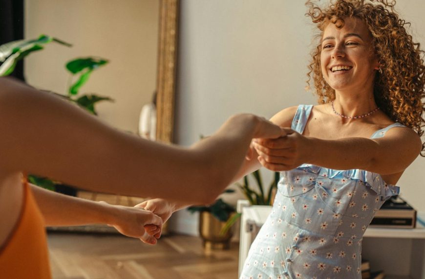 A cheerful moment captured as two adults dance playfully in a bright indoor setting.
