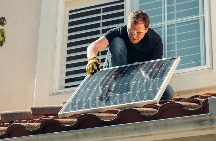 Solar technician installing a photovoltaic panel on a rooftop, promoting renewable energy.